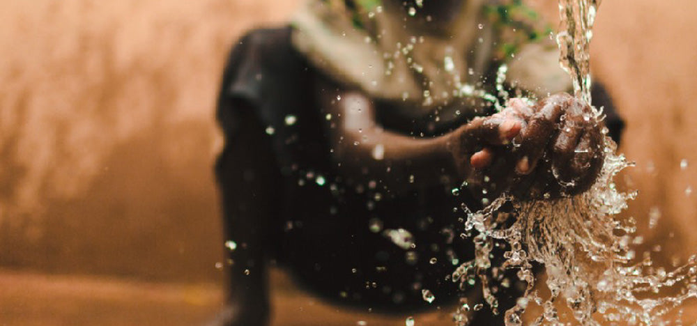 Person splashing water with hands creating dramatic water drops
