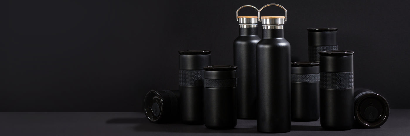 Black water bottles with gold caps on a dark background