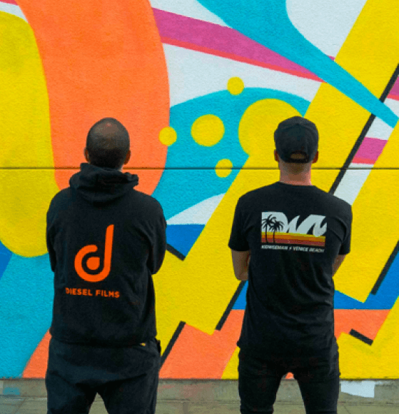 Two people viewing a colorful abstract mural
