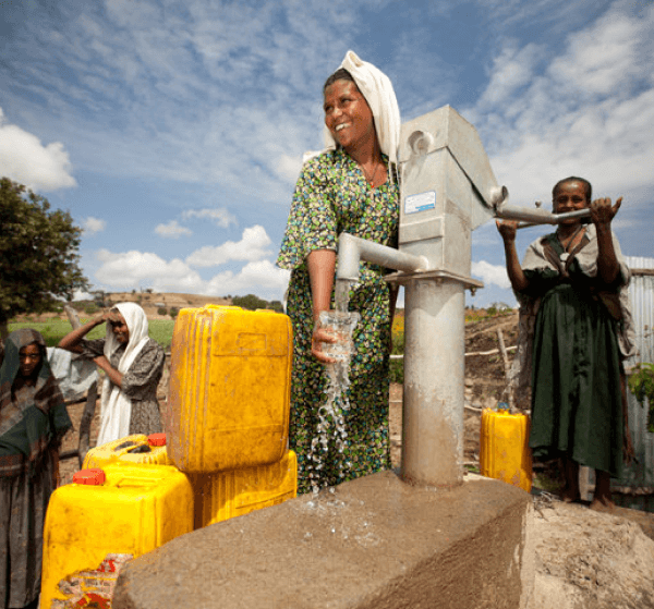Women collecting water from a well pump