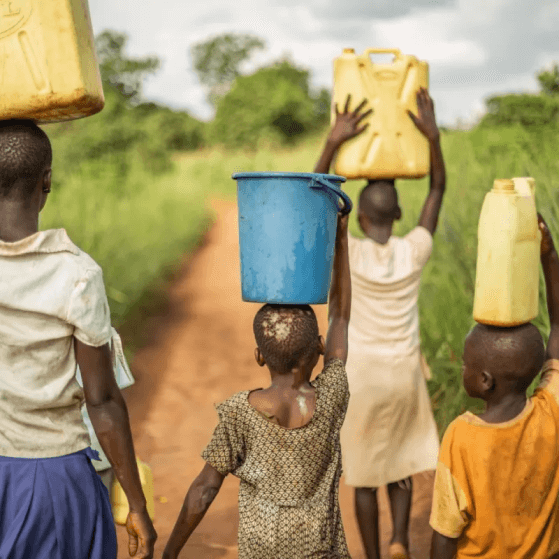Children carrying water containers in rural area